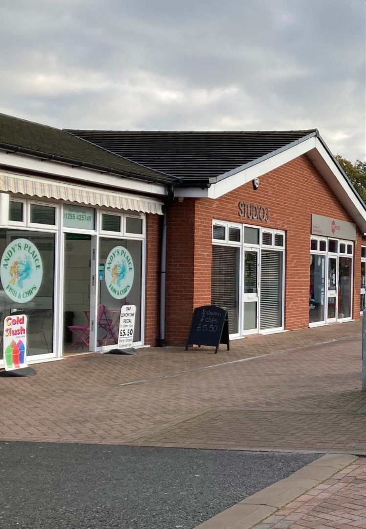 Row of shops including a fish and chip shop and a studio.