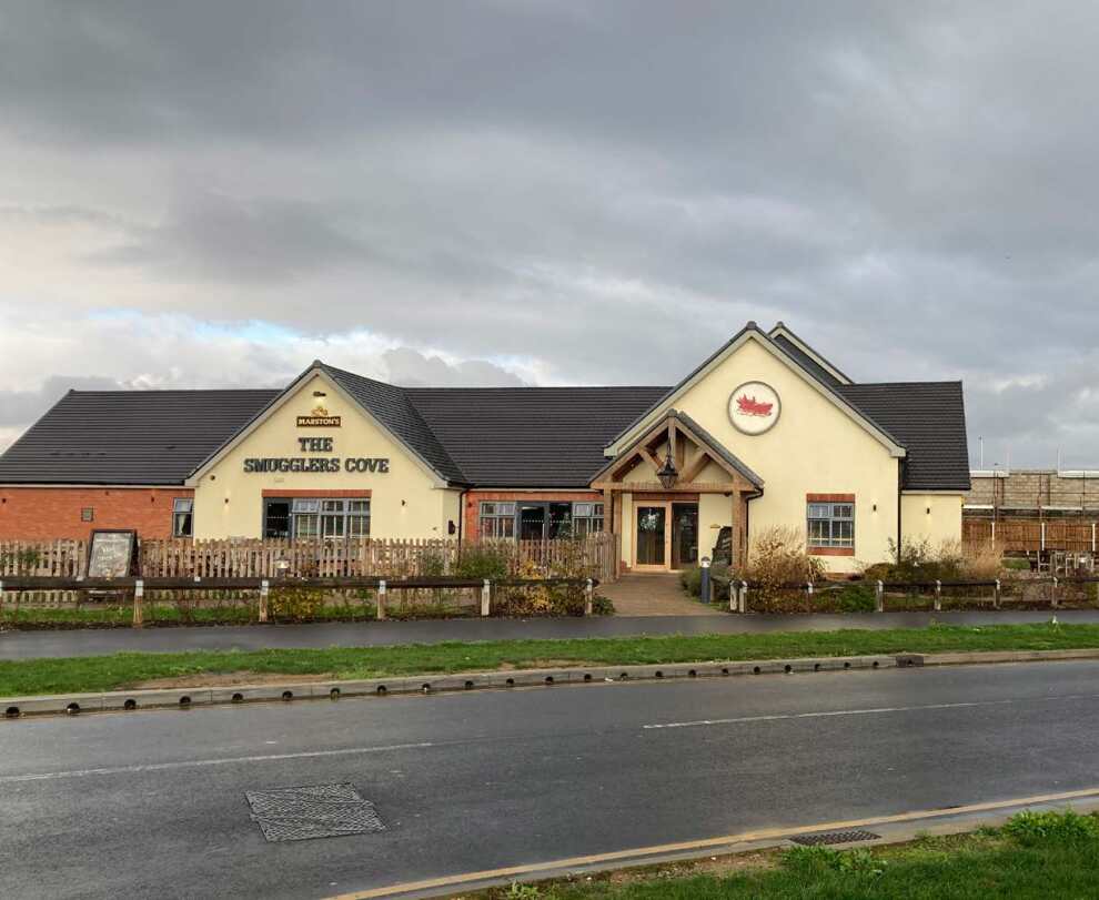 Large building with a sign on the front saying Smugglers Cove