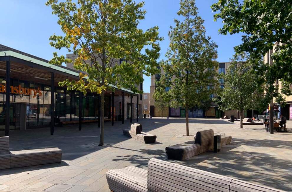 Outside a Sainsbury's with trees, benches and a pathwalk.