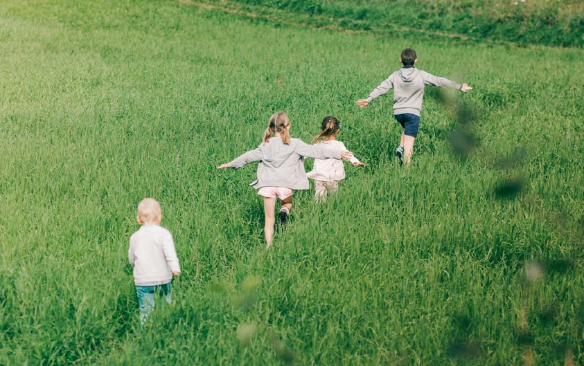 Children walking through long grass