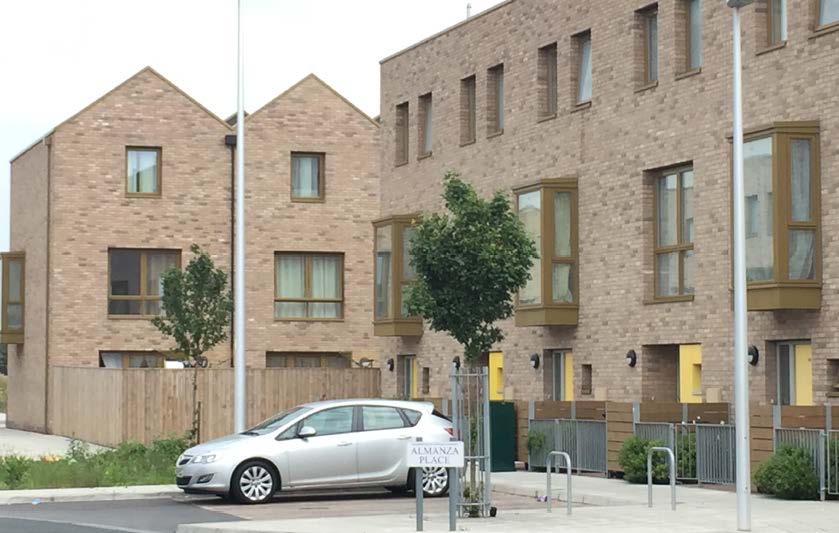 Modern houses with small trees and a car parked outside.